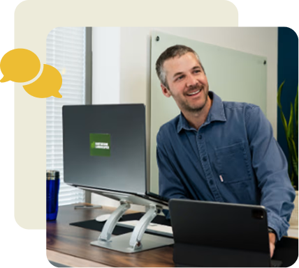 BBB team member smiling at his desk